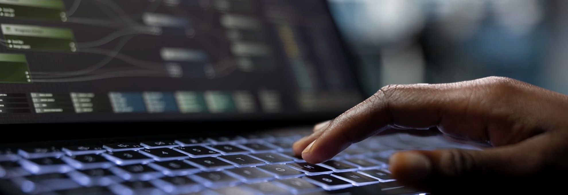 Mão operando teclado com interface de sistema ao fundo